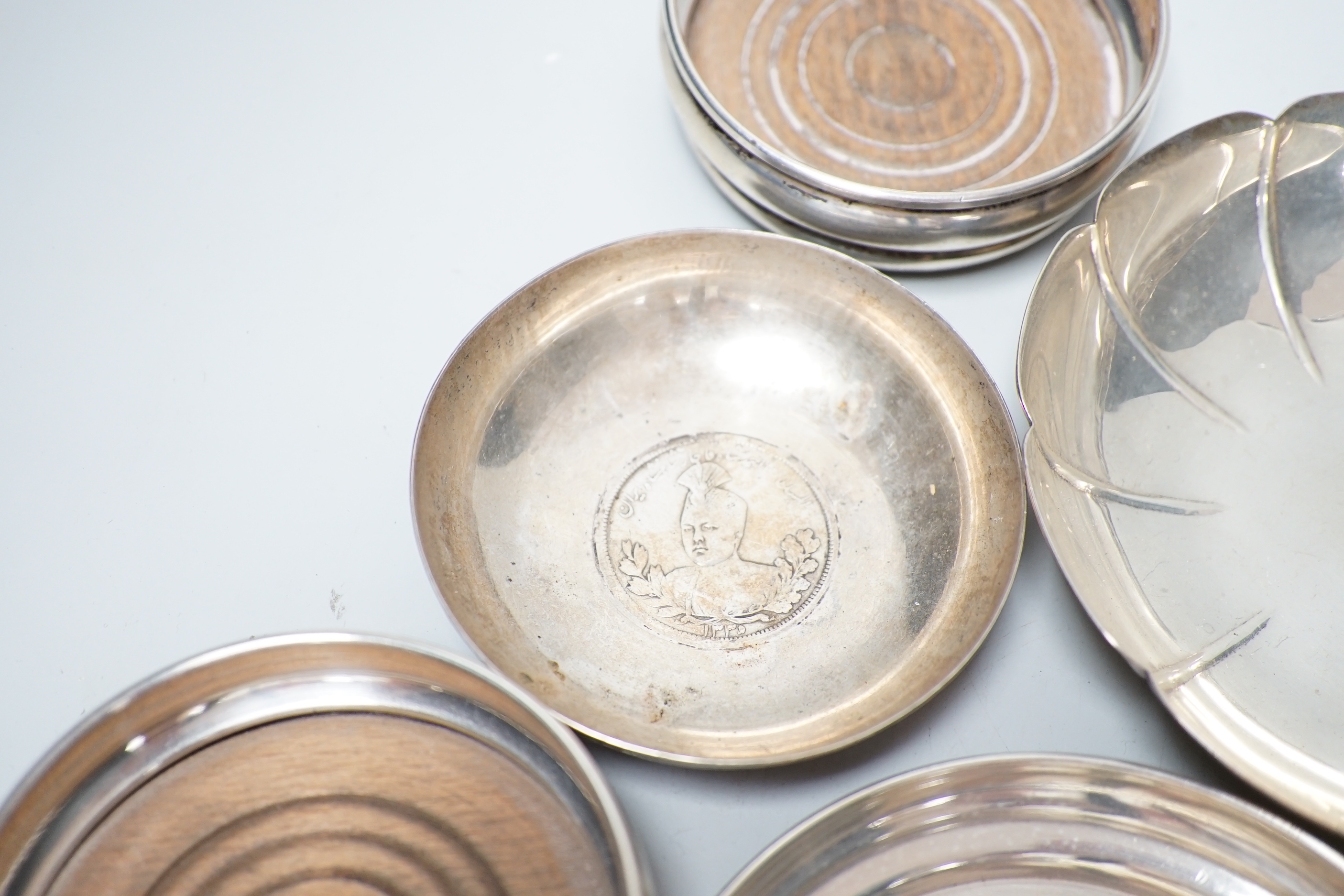 A modern pair of small silver mounted coasters, diameter 79mm, seven other silver or white metal dishes including Dutch and a small silver cream jug.